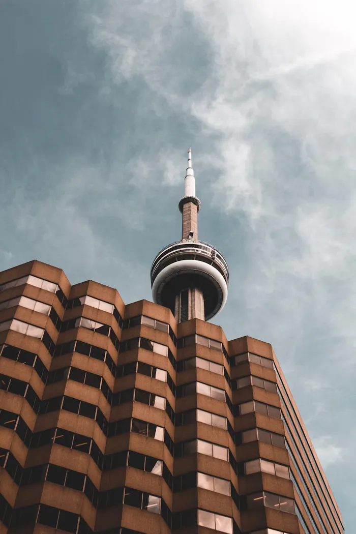CN tower visible over a roofline from pedestrian view. Toronto, Ontario.
