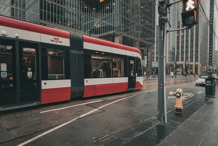 Traffic featuring pedestrians and rail transit.